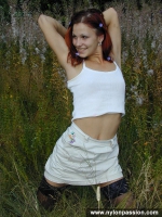 Teen redhead in black stockings posing outdoor