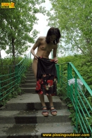 Teen brunette dousing outdoor park ladder with pissing